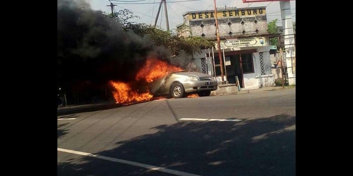 Mobil yang terbakar di simpang tiga Jl Raya Sembung, Kecamatan Perak, Kabupaten Jombang, Minggu (11/6/2017). foto: ROMZA/ BANGSAONLINE