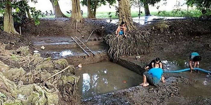 Suasana kolam sedang yang sedang dibersihkan oleh warga.