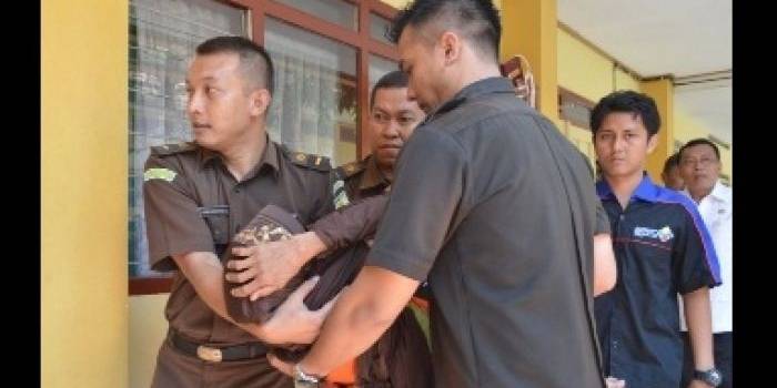 Nenek Asyani digotong petugas sesaat setelah pingsan saat akan memasuki ruang sidang. foto: Hadi Prayitno/BangsaOnline.com