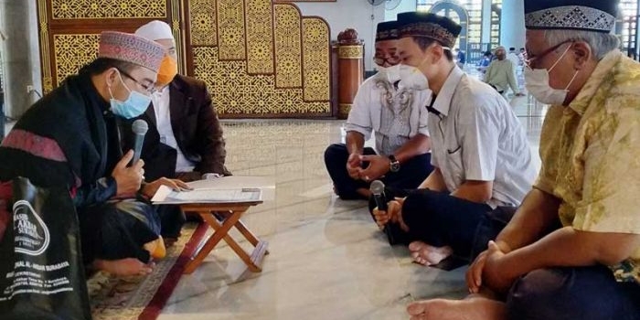 Zakaria BJ Marcello (tengah, pegang mik) didampingi dua saksi sedang mengikrarkan dua kalimat syahadat di hadapan Imam Masjid Al-Akbar Surabaya, Ustadz Nasikh Hidayatullah, Jumat (18/9/2020). foto: mma/ bangsaonline.com