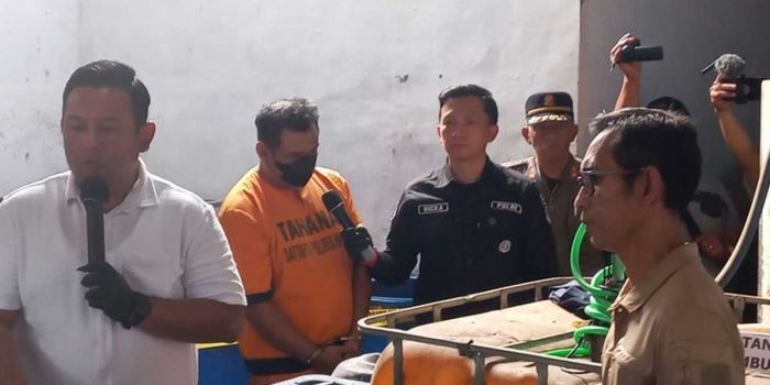 Pelaku pembuatan minuman keras ilegal, MR saat diinterogasi polisi di tempat kejadian perkara (TKP), Kamis (6/6/2024).