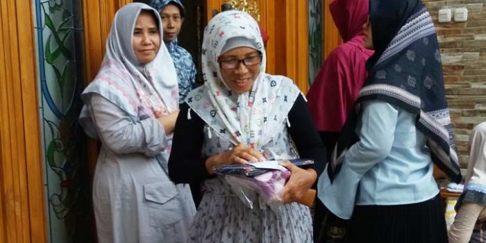 Nyai Hj Alif Fadlilah (paling kiri) bersama putrinya, Neng Zahroh (paling kanan) saat memberikan bingkisan Idul Fitri kepada para janda di kediaman Gus Barra Jalan Siwalankerto Utara, Surabaya Senin sore (3/6/2019). foto: BANGSAONLINE.com