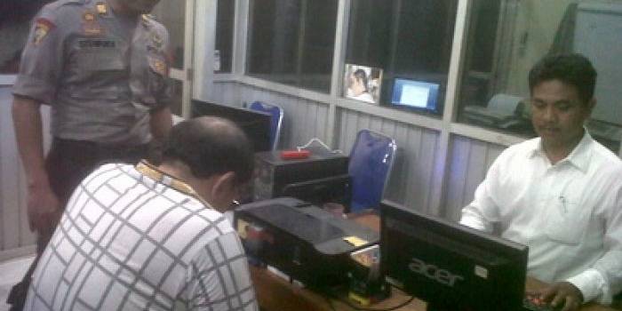 BS (baju motif kotak-kotak) saat menjalani pemeriksaan di unit pidana ekonomi Sat Reskrim Polres Kediri Kota, Senin (7/4/2014).foto:arief kurniawan/BANGSAONLINE