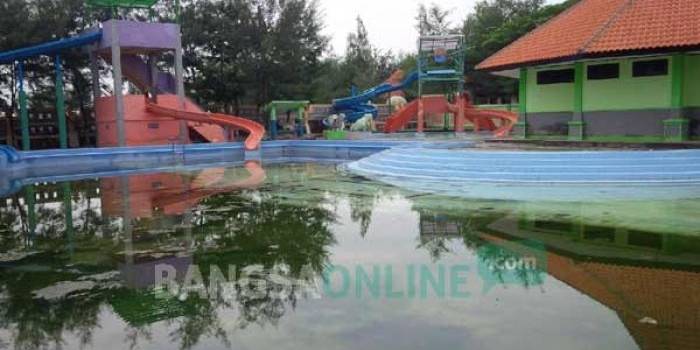 SEPI: Obyek wisata berupa kolam renang sepi pengunjung karena kurang terawat. Tampak banyak tumbuhan lumut  di sekitar kolam. foto: suwandi/ BANGSAONLINE