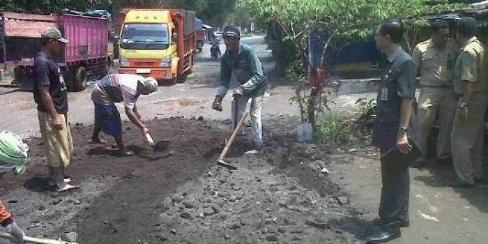 Kegiatan mengurug Jalan Bulang-Simpang dengan Urug Sirtu. foto:daryanto/BANGSAONLINE