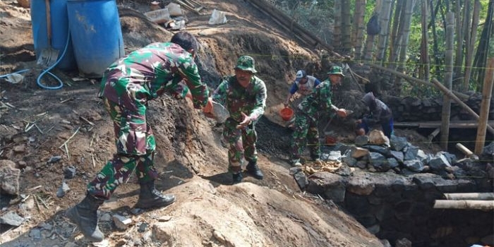 Pekerjaan menaikkan dan menurunkan pasir dari atas truk yang dilakukan Satgas TMMD ke-106 Kodim Malang-Batu.