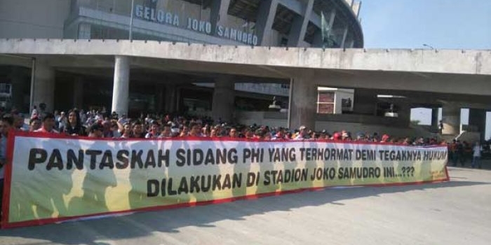Ratusan buruh Smelting membentangkan spanduk raksasa di depan Stadion Gejos. foto: syuhud/ bangsaonline