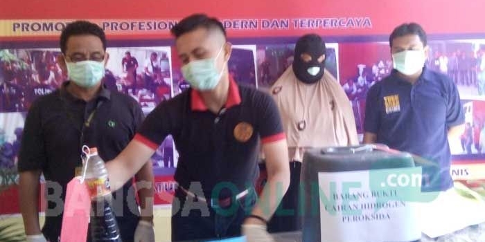 Petugas memamerkan tersangka dan barang bukti berupa bahan kimia.
