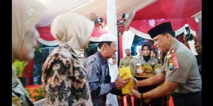 Wakapolda Jatim Brigjend Pol Widodo Prihartopo saat menyerahkan bingkisan. Foto: SYUHUD A/BANGSAONLINE.