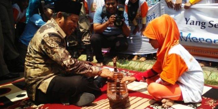 Bupati Saiful Ilah asyik bermain dakon dengan anak yatim yang mengingatkannya pada masa kecil, kemarin. foto : nanang ichwan/BangsaOnline.com