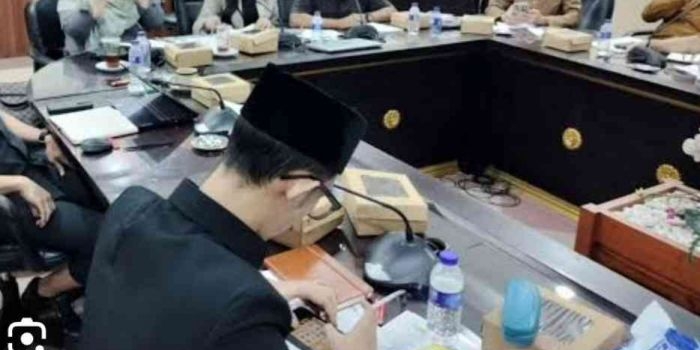 Ahmad Assidiqi tampak sedang sibuk main game dan merokok saat mengikuti rapat membahas stunting di Gedung DPRD Jember Jawa Timur. Foto: Instagram