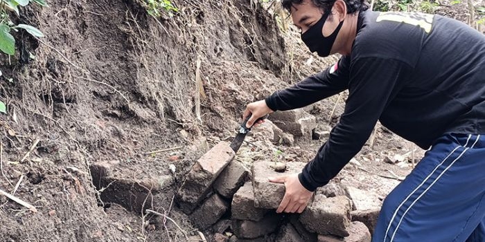 Nino Subekti, saat menunjukkan tumpukan batu bata kuno yang diduga sebagai objek cagar budaya. (foto: MUJI HARJITA/ BANGSAONLINE)