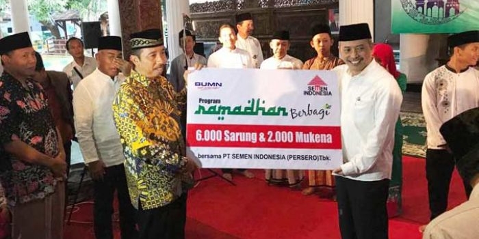 Direktur SDM dan Hukum Agung Yunanto (baju putih) secara simbolis menyerahkan bantuan sarung dan mukena kepada bupati Rembang Abdul Hafidz. foto: SYUHUD/ BANGSAONLINE