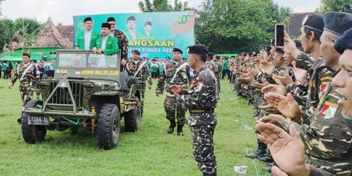 Ketua PC GP Ansor Kabupaten Kediri, Agus Rizmi Haitami Azizi, saat mengecek pasukan dengan naik Jeep jadul. foto: ist.