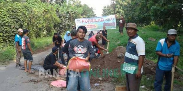 Aksi ratusan warga memperbaiki kerusakan jalan raya Kesamben. Ini wujud keprihatinan terhadap minimnya tanggungjawab pemda. foto: YUDI EP/ BANGSAONLINE