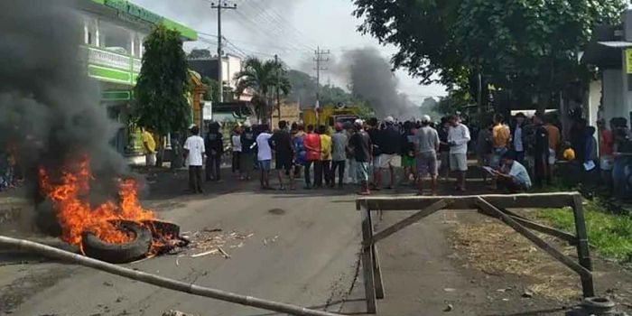 Massa aksi yang tergabung dalam Persatuan Tumangan Gunung Sadeng saat membakar ban di tengah jalan.