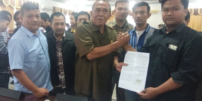 Sunarto dan dua pimpinan DPRD Kota Mojokerto yang lain mengangkat tanda tangan berisi petisi penolakan perubahan UU KUHP dan UU KPK. Nantinya petisi di atas materai ini akan diteruskan ke DPR RI. (foto: YUDI EP/ BANGSAONLINE)