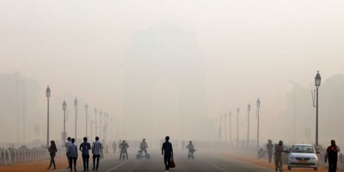 Orang-orang berjalan di depan kabut asap menutupi peringatan perang Gerbang India di Delhi, India.