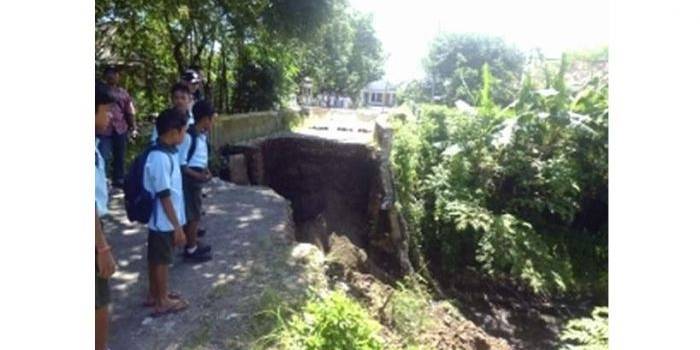 PUTUS-Nasib jembatan di Desa Candiwatu Pacet akibat terjangan derasnya aurs sungai, Kamis (29/1) malam. (gunadhi/BangsaOnline)