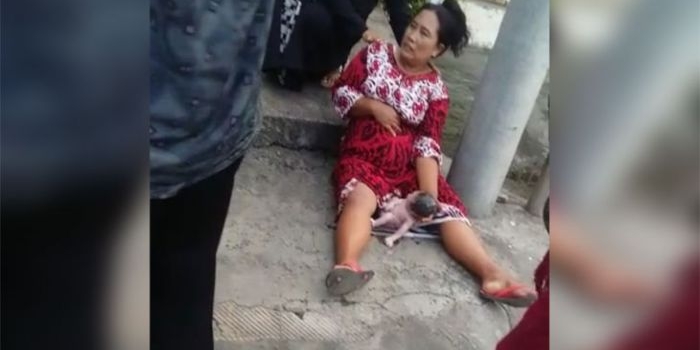 Wanita ini memegangi bayi yang baru brojol sendiri dari kandungannya, di pinggir jalan KH Wahid Hasyim Sampang.