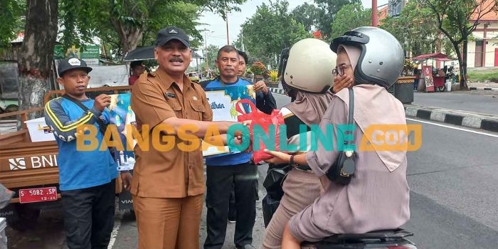 Kepala Dinsos P3A Kota Mojokerto saat membagikan takjil ke masyarakat. Foto: ROCHMAT SAIFUL ARIS/BANGSAONLINE