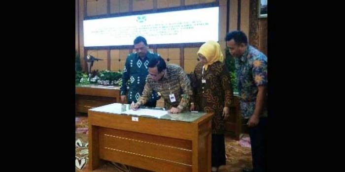 Bupati Sambari didampingi Wakil Ketua DPRD Nur Saidah dan pejabat Forkopimda saat teken berita acara penyerahan pengelolaan SLTA. foto: SYUHUD/ BANGSAONLINE