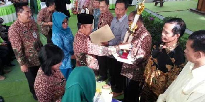 Bupati magetan Sumantri didampingi Kepala BLH Bambang Setiawan menyerahkan penghargaan kepada Sri Partiyah dan beberapa orang aktivis lingkungan pada acara peringatan hari Lingkungan Hidup di kantor BLH, Kamis (20/08). (nanang ari/BANGSAONLINE)