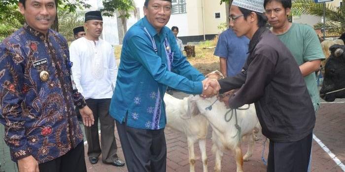 KURBAN. Bupati Wabup Gresik Sambari HR-Moch Qosim ketika menyeraghkan kambing kurban. foto : syuhud/bangsaonline