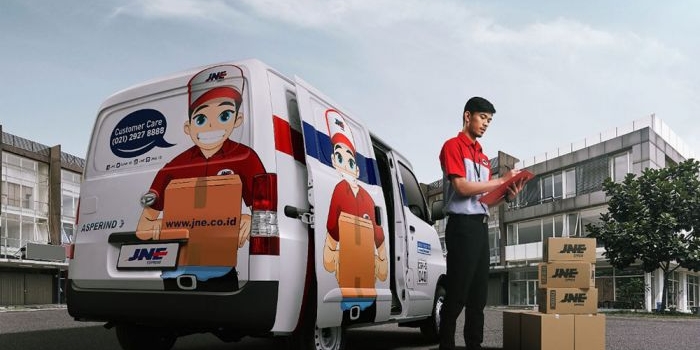 Salah satu karyawan JNE saat sedang mempersiapkan pengiriman.