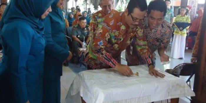 Moch Qosim ketika menorehkan canting untuk melukis batik UKS di kain. (syuhud/BANGSAONLINE)