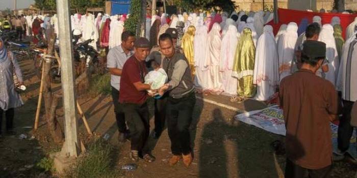 Siswa pingsan saat dibopong keluar dari saf salat Kusuf berjamaah. (foto: rahmatullah/ BANGSAONLINE)