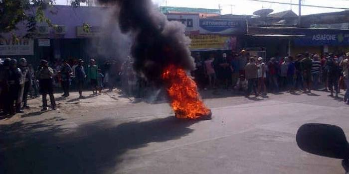 BAKAR BAN. Warga Dolly menggelar aksi pemasangan plakat dengan membakar ban di ujung Jalan Dukuh Kupang. 