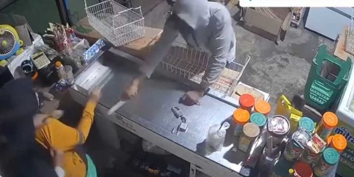 Tangkapan layar video rekaman CCTV saat pelaku mengancam karyawan menggunakan pisau.