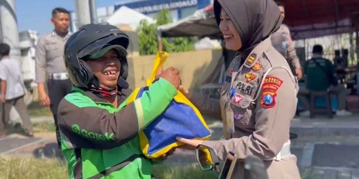 Anggota Polresta Sidoarjo saat membagikan paket sembako kepada pengendara yang tertib berlalu lintas (dok. Ist)