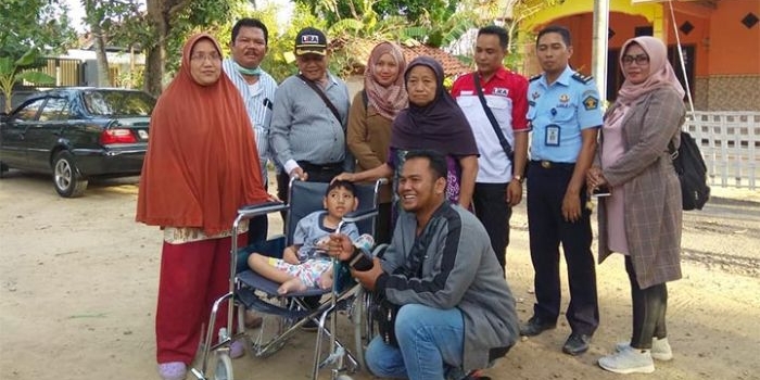 Kalapas Klas II Pamekasan, Hanafi, foto bersama Agam usai memberikan bantuan kursi roda.