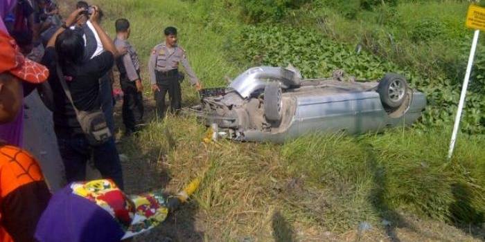 TERBALIK– Kondisi mobil sedan yang terbalik setelah diseruduk kereta api (KA), di dekat perlintasan rel KA tanpa palang pintu, di Desa Plosowahyu Kecamatan Kota Lamongan, Jum’at (25/7/2014). foto : haris sugianto/BangsaOnline

