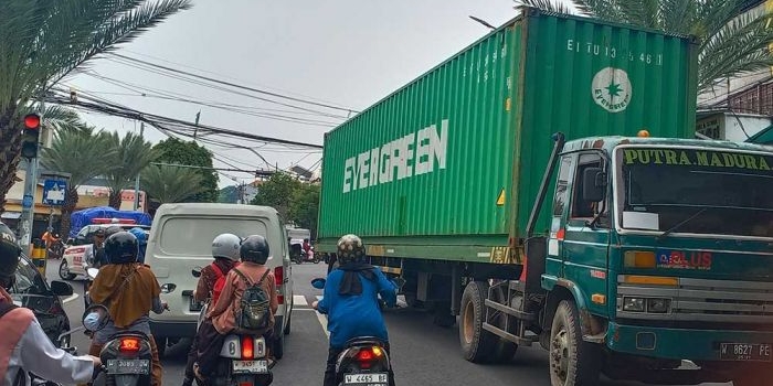 Truk tronton berhenti di tengah jalan usai nyangkut kabel seluler yang menggelantung di perempatan Jalan Giri, Kebomas, Gresik. Foto: SYUHUD/ BANGSAONLINE