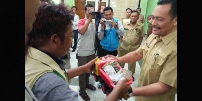 Sejumlah warga menyerahkan hasil penggalangan koin kepada Sekwan DPRD Jombang,  Pinto Widiarto, Selasa (26/7) siang. foto: ROMZA/ BANGSAONLINE