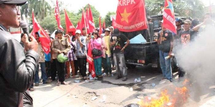 Massa pengunjuk rasa membakar uang mainan di depan kantor Kejaksaan. foto: TRI SUSANTO/ BANGSAONLINE