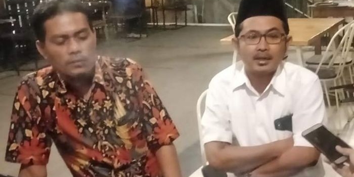 Ketua PC GP Ansor Gresik, Agus Junaidi Hamzah (berpeci hitam) memberikan keterangan kepada wartawan. foto: DIDI ROSADI/ BANGSAONLINE