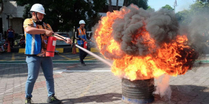 Seorang karyawan pelindo mengikuti lomba memadamkan api menggunakan alat pemadam api ringan (APAR). Foto: Ist