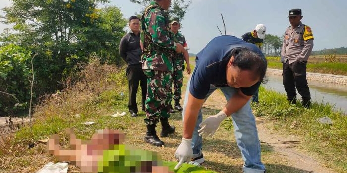 Petugas saat mengidentifikasi jenazah perempuan yang ditemukan tewas tergorok di Desa Keting, Kecamatan Jombang, Jember.