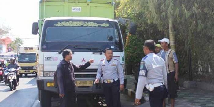 Petugas mengusir dump truk yang parkir sembarangan di jalan. (foto: khumaidi/BANGSAONLINE)