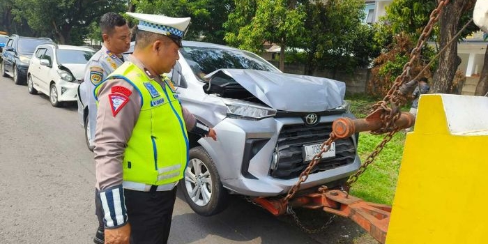 anggota kepolisian saat melakukan pengecekan terhadap salah satu mobil yang terlibat kecelakan beruntun di KM 748/B ruas Tol Sidoarjo arah Waru, Jumat (15/12/2023).