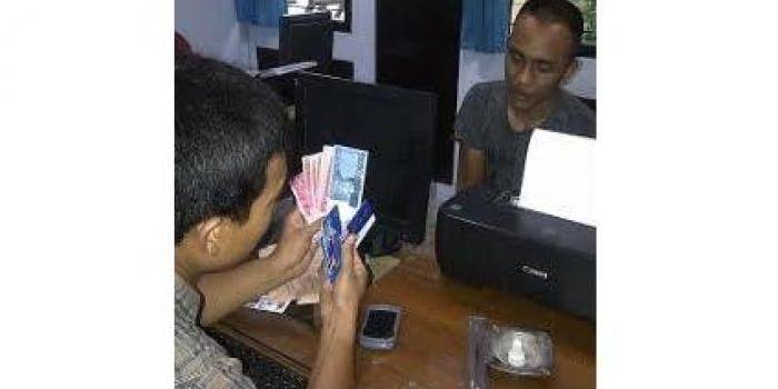 Tersangka beserta barang bukti berupa uang saat diperiksa petugas. (Gunadhi/BangsaOnline)