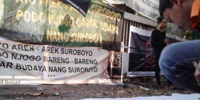 Para mahasiswa dan pemuda Surabaya menandatangani komitmen untuk menjaga bangunan cagar budaya yang ada di Surabaya di depan Rumah Radio Bung Tomo yang telah dibongkar di Jalan Mawar, Jumat (13/5). foto: suarasurabaya