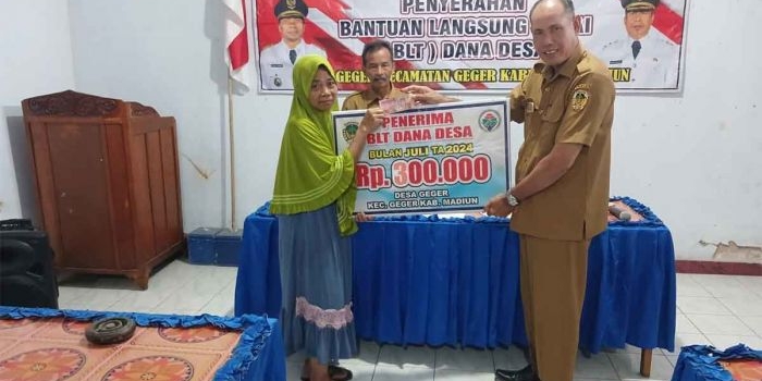 Kepala Desa Geger, Samsudin, saat memberikan bantuan kepada warga.