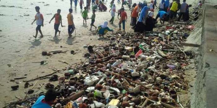 PEDULI: Para anak yatim dan pendampingnya melakukan bakti sosial bersih pantai utara yang berada di kawasan Jalan RE Martadinata Tuban. foto: suwandi/BANGSAONLINE