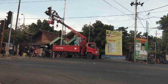 Pemasangan tiang TL di perempatan Gading Rejo. foto: SUPARDI/ BANGSAONLINE