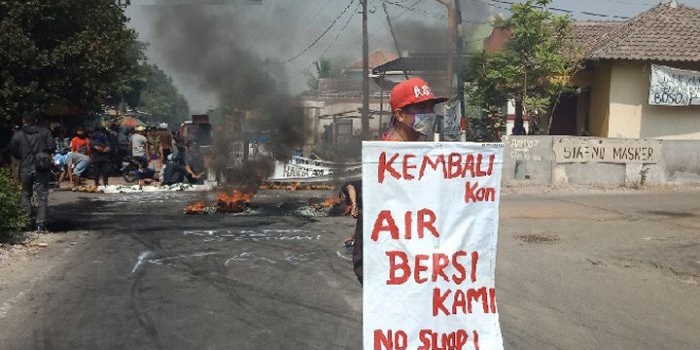 Aksi warga Desa Baujeng memprotes bau limbah dengan menutup jalan dan membakar ban.